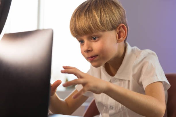 Happy boy sitting at his desk With laptop computer. to learn General Mathematics