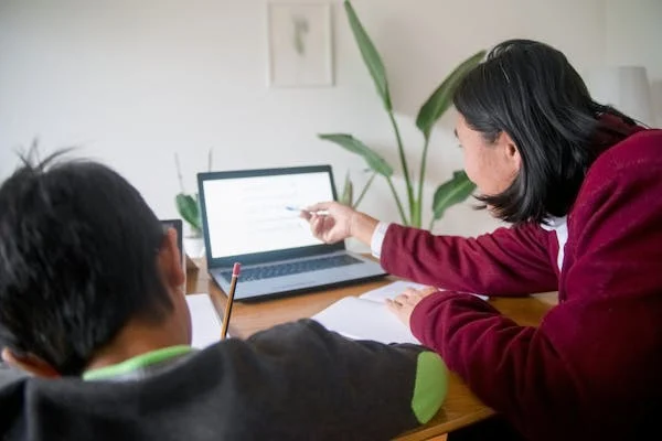 A teacher teach the the student UAE Studies with the help of Laptop