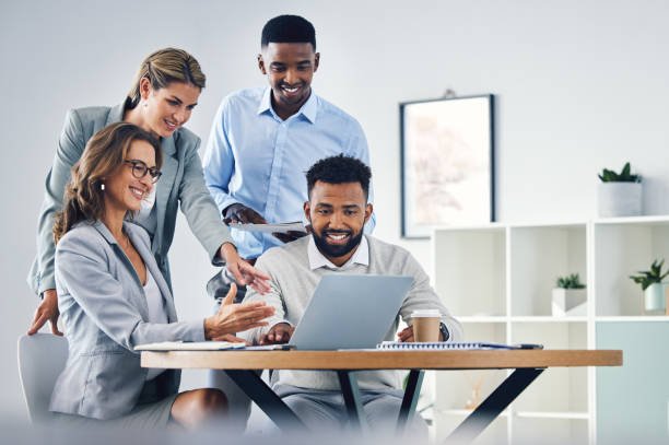 Business team brainstorming around laptop